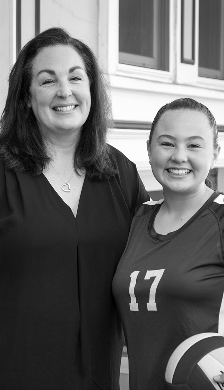 Lisa and daughter, SF Natives. Putting them first since 1991. Mother with shoulder length brown hair embraces her teen daughter. Daughter wears a sports jersey with the number
